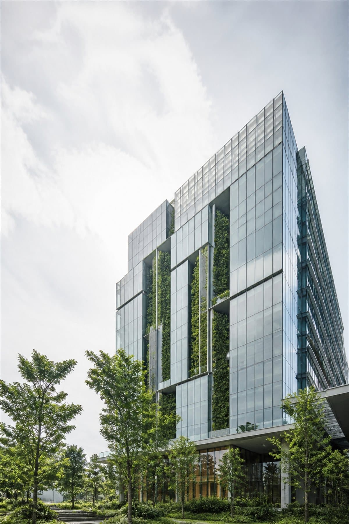 Modern glass corporate headquarters with integrated greenery representing ESG and sustainability reporting advisory